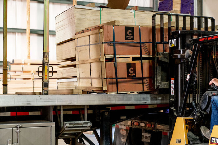 Softwood & hardwood lumber products in stacks and boxes carried by a forklift
